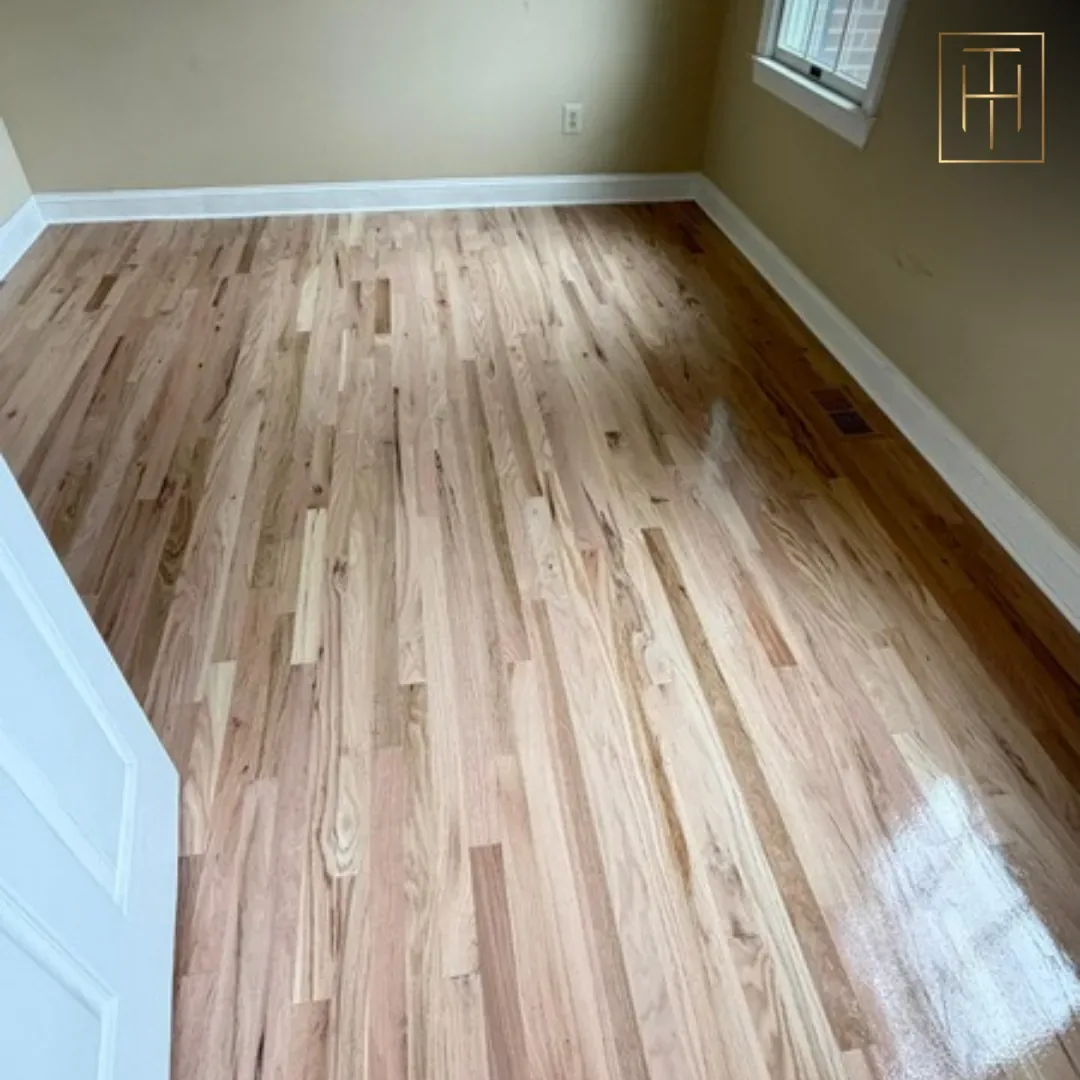 Red oak hardwood floor mid-refinishing showing fresh sanded planks in Wayne PA bedroom