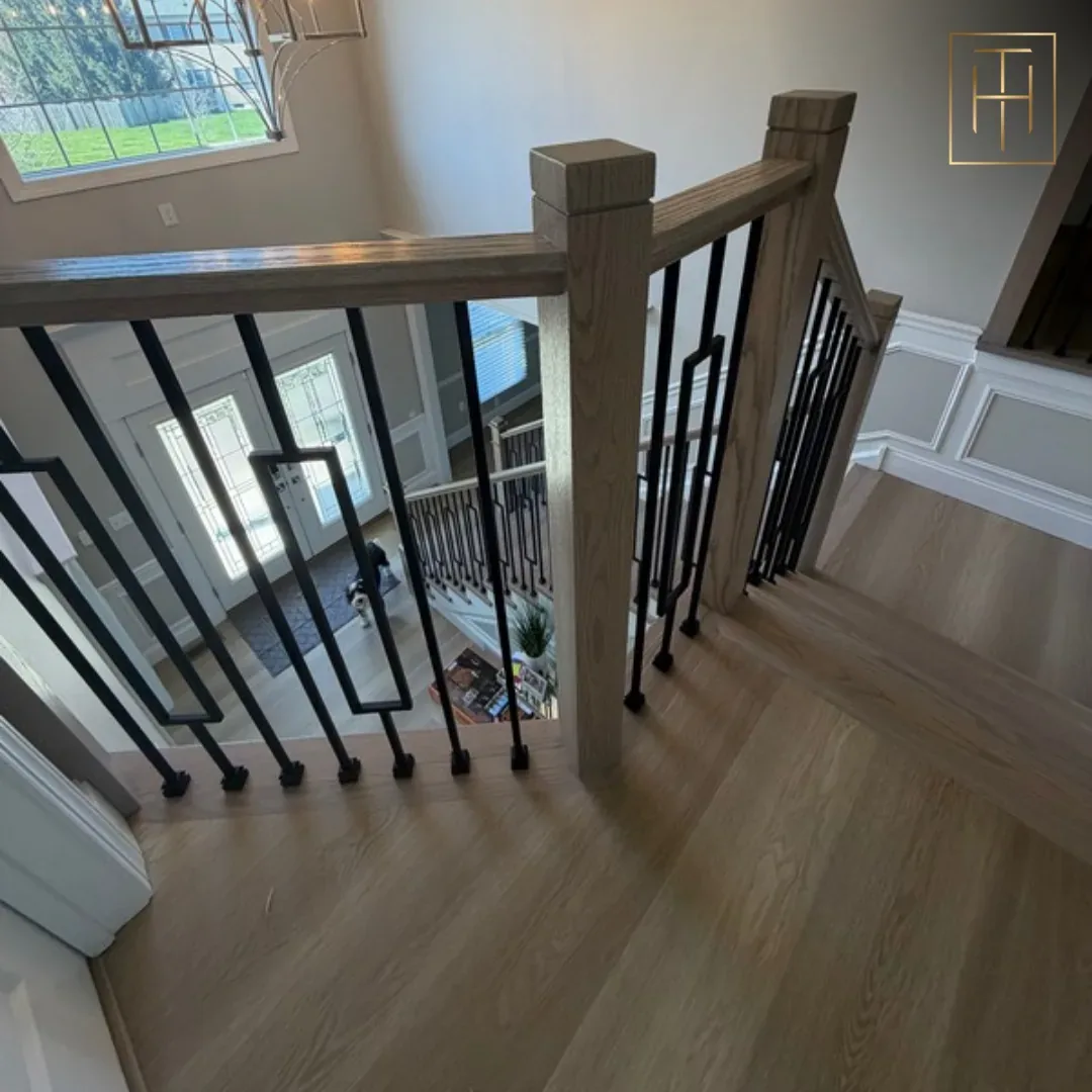 White oak staircase with iron balusters viewed from upper landing in Bryn Mawr PA home