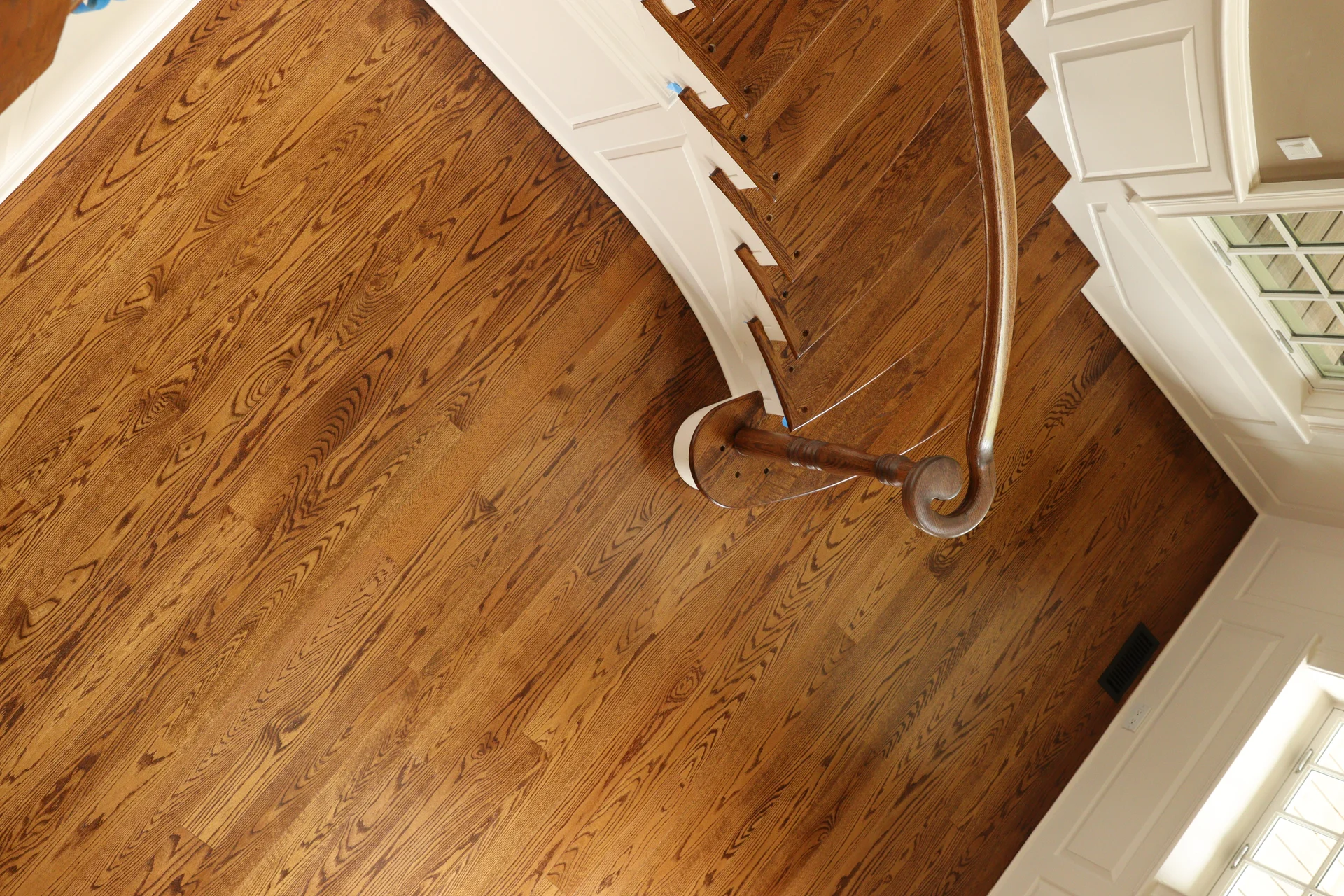 Elegant Hardwood Flooring with Custom Details Beautiful new hardwood flooring installation with rich brown tones and a grand staircase. by Tesla Hardfloor in Radnor, PA