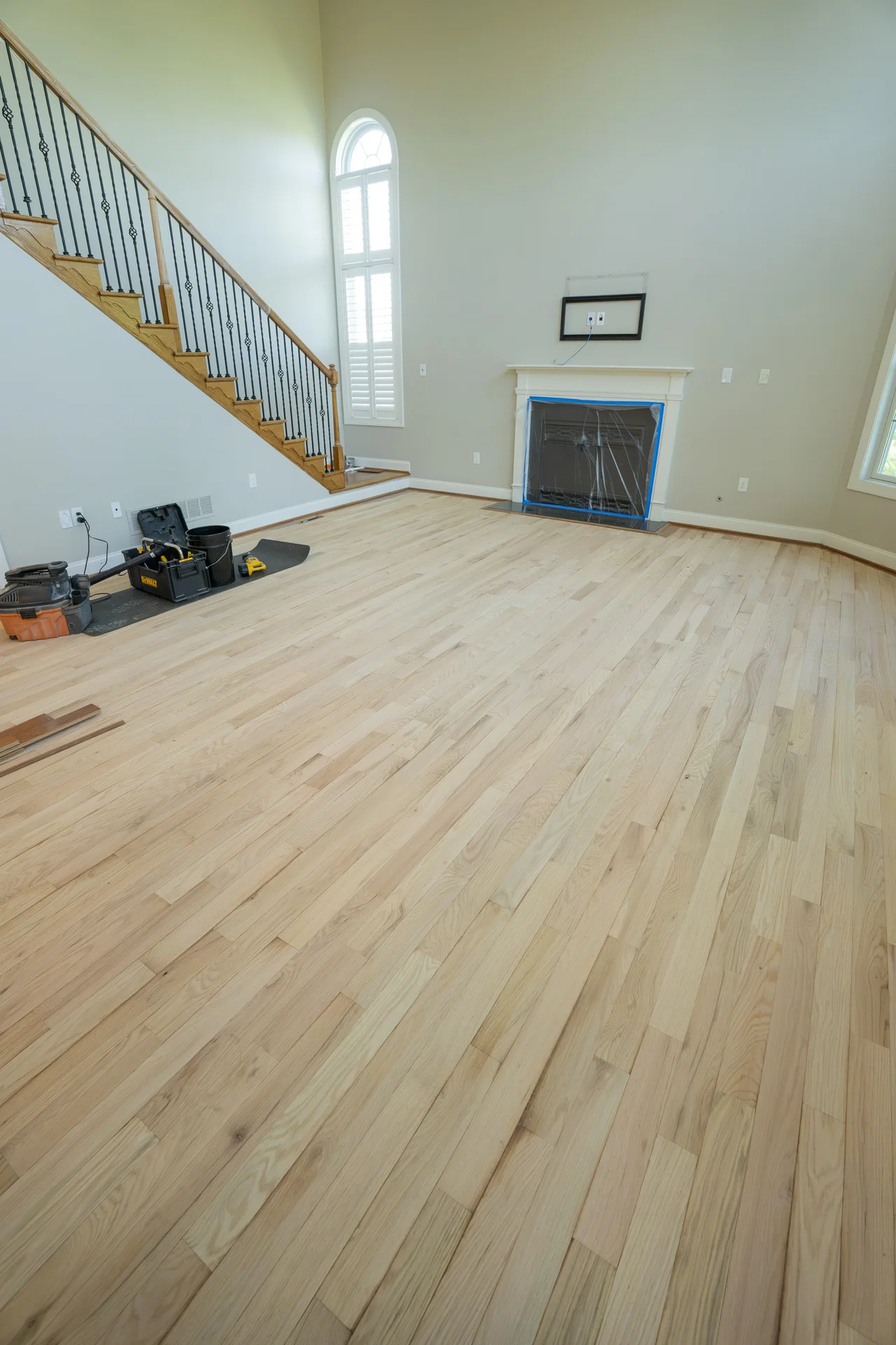Expert Vinyl Flooring Installation Light-colored plank hardwood flooring installation with tools and materials in a room by Tesla Hardfloor in Doylestown, PA