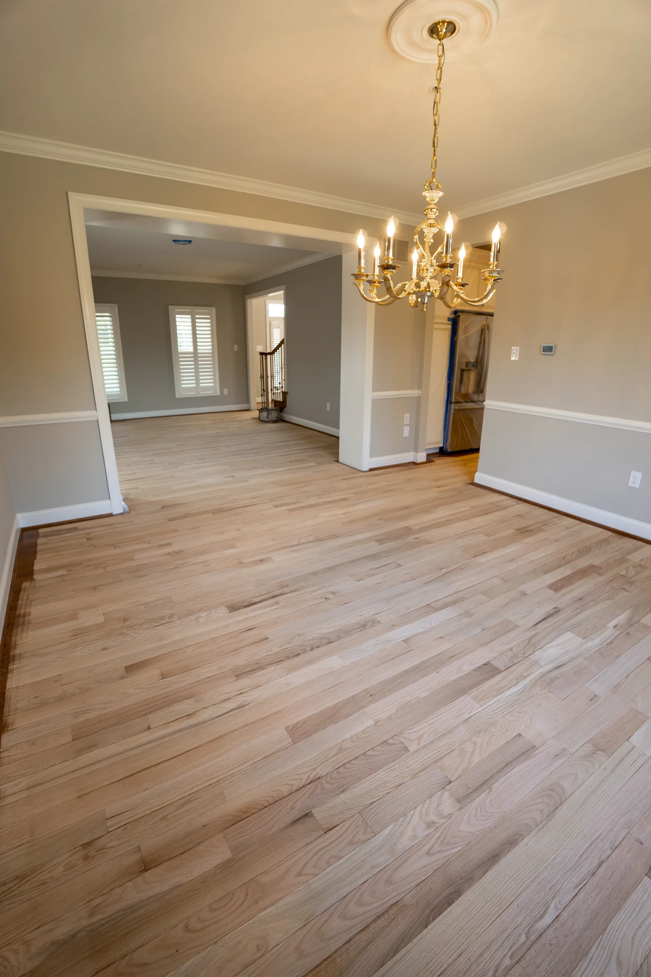 Matte Finish Hardwood Flooring in Newtown, PA Light natural hardwood flooring with matte finish in gray wainscoted room. by Tesla Hardfloor in Newtown, PA