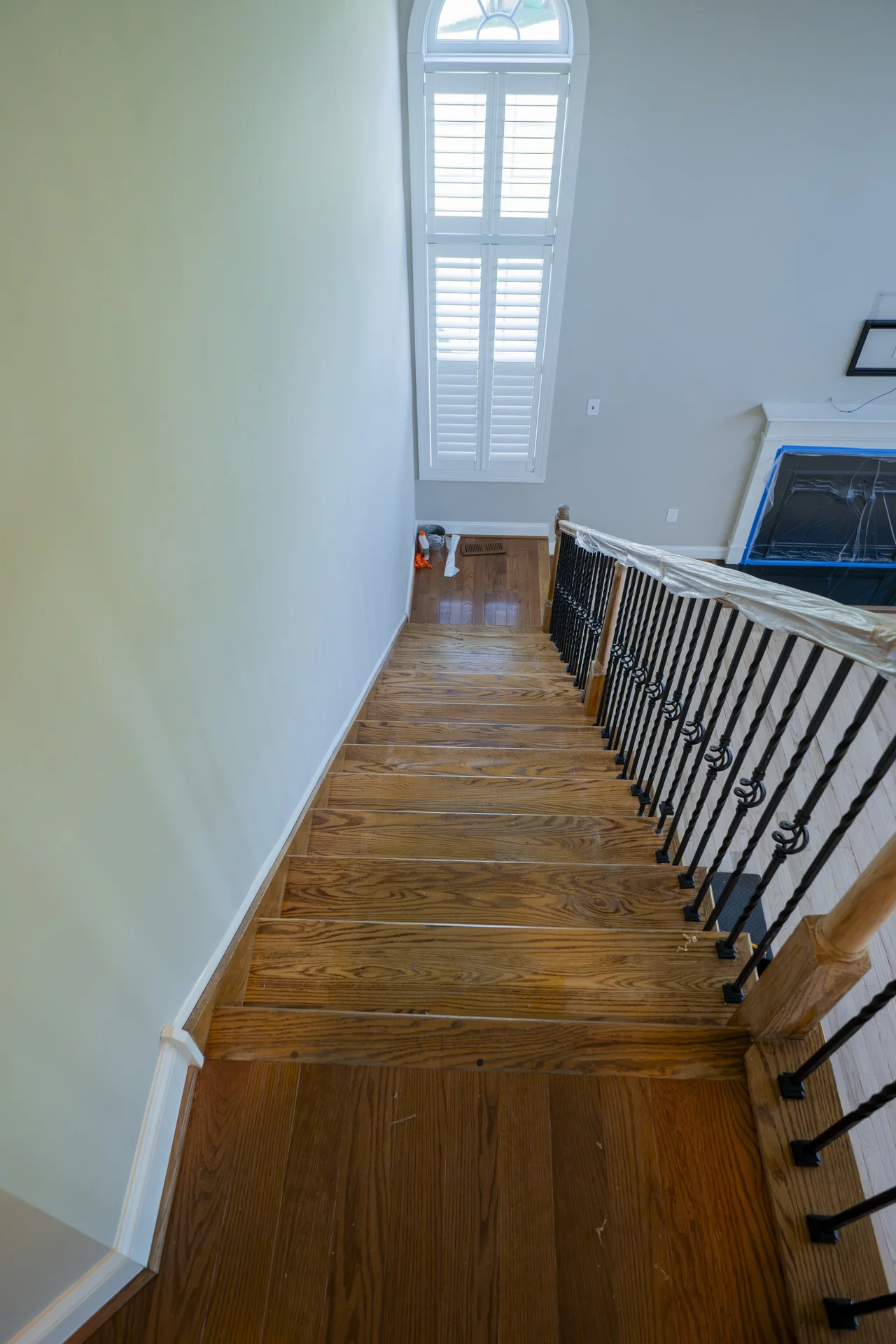 Newly Installed Hardwood Stairs in Blue Bell, PA Downward view of newly installed hardwood stairs and landing with black iron balusters. by Tesla Hardfloor in Blue Bell, PA